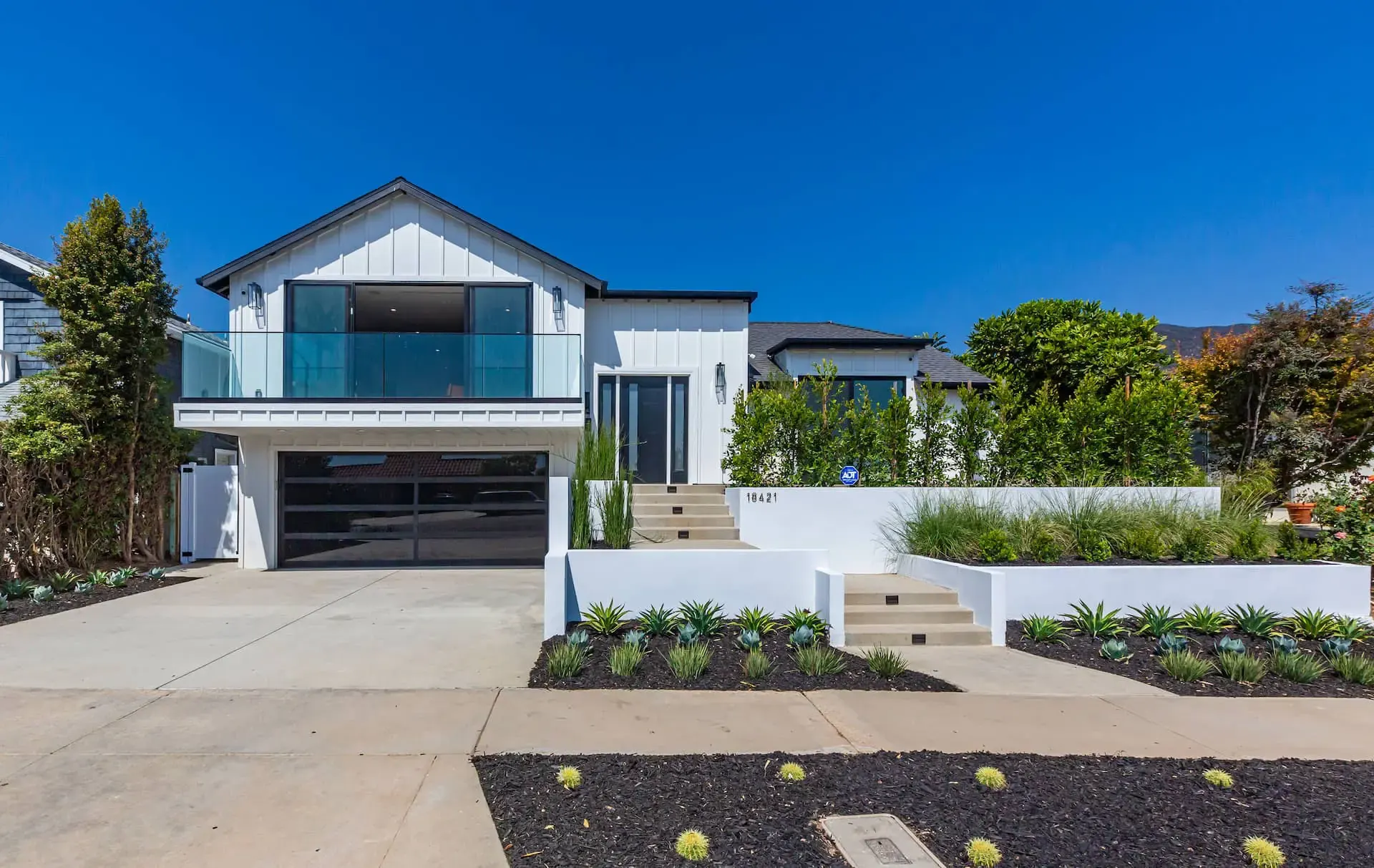 A bright home exterior with planted terraces
